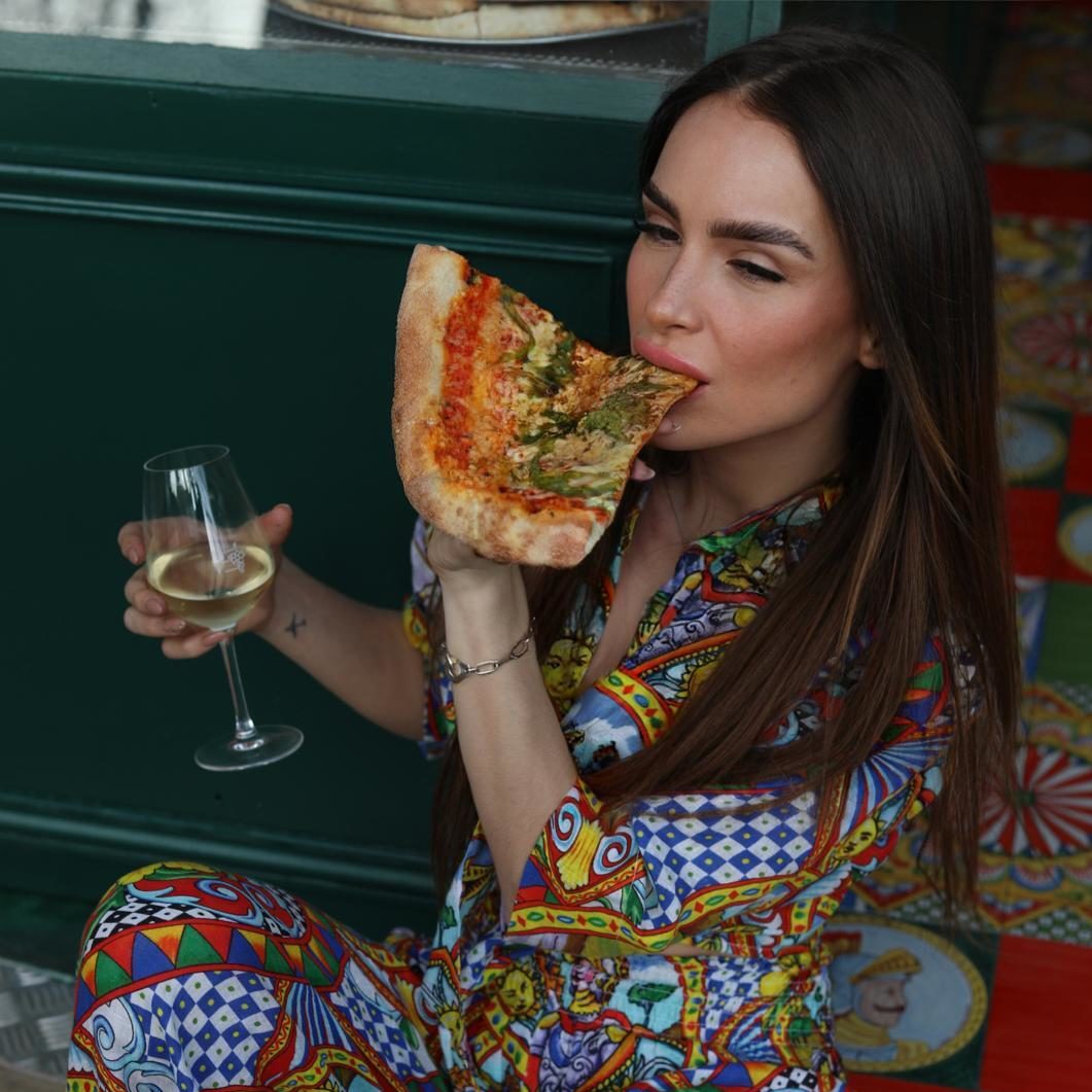 femme qui croque dans une part de pizza